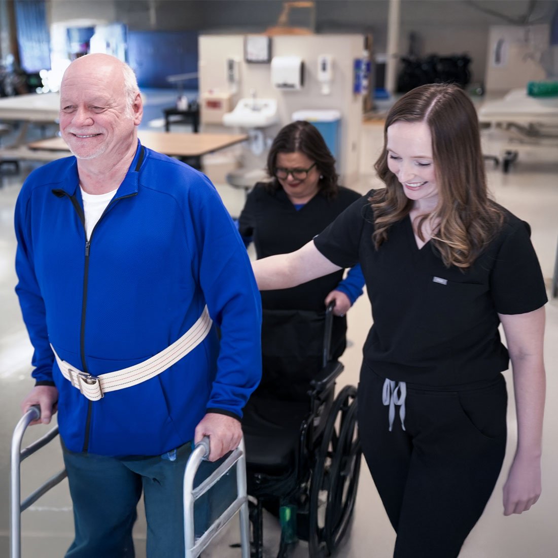 Patient using a walker to get up out of a wheelchair
