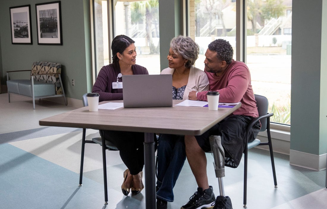 A case manager speaking with a patient and his caregiver