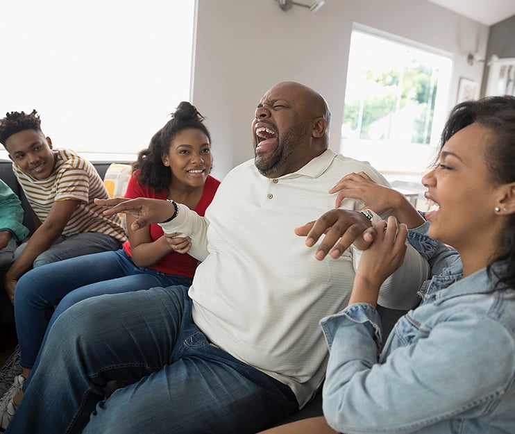 man on couch laughing