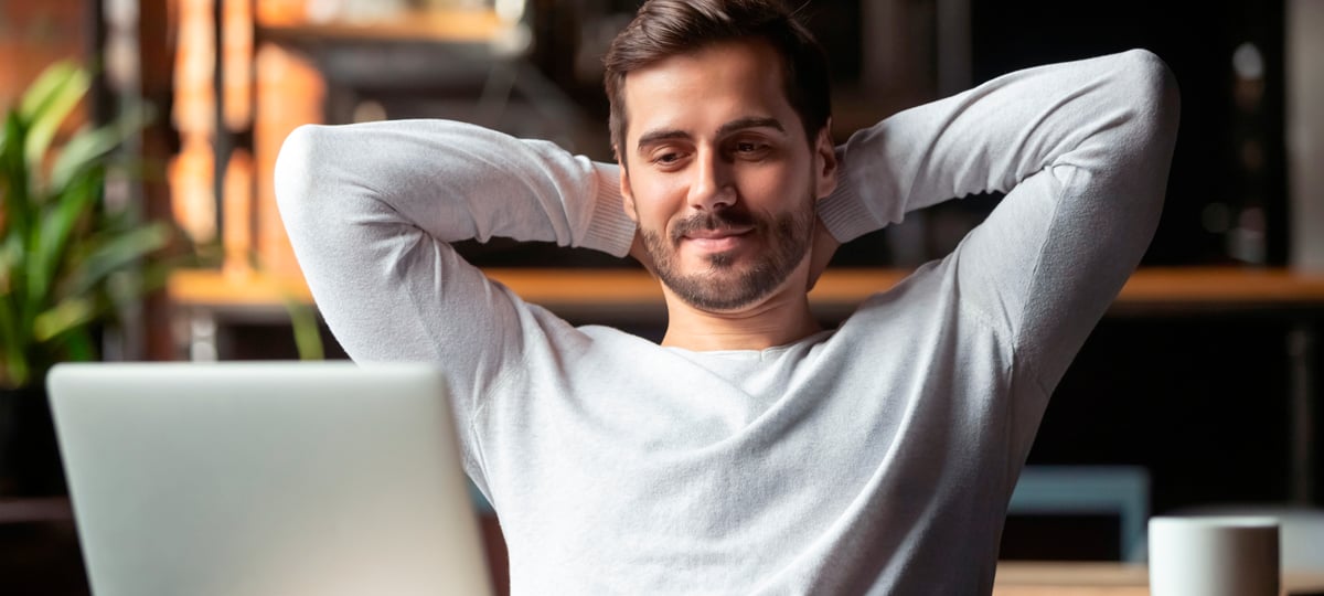 man sitting behind laptop looking relaxed
