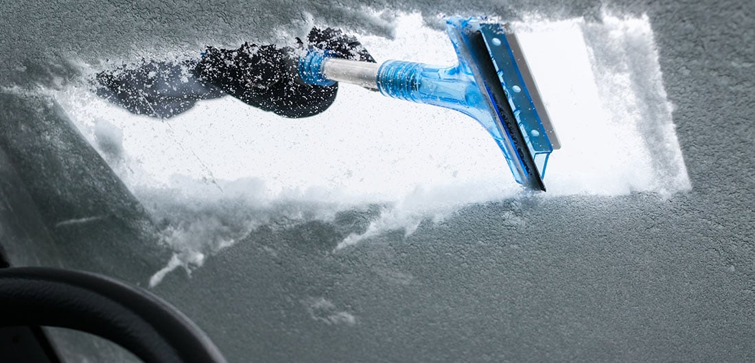 scraping snow off of windshield