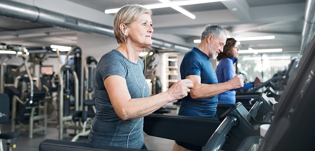 senior woman runs on treadmill at gym