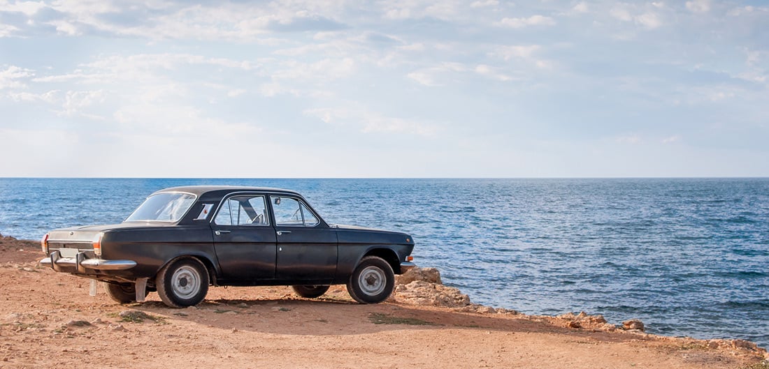 older car next to a beach