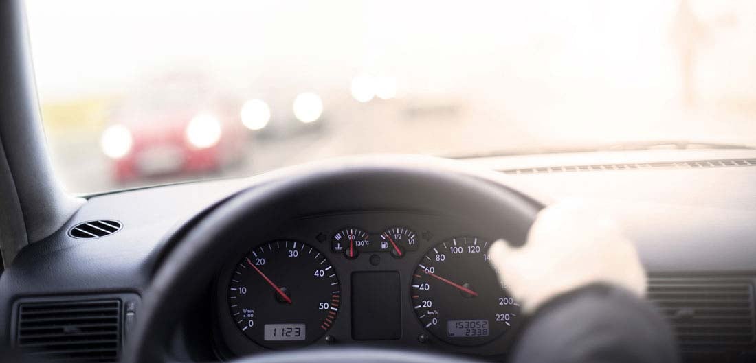 car odometer with hand on steering wheel
