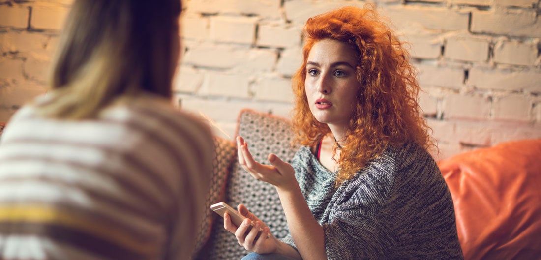female roommates have discussion with serious expressions