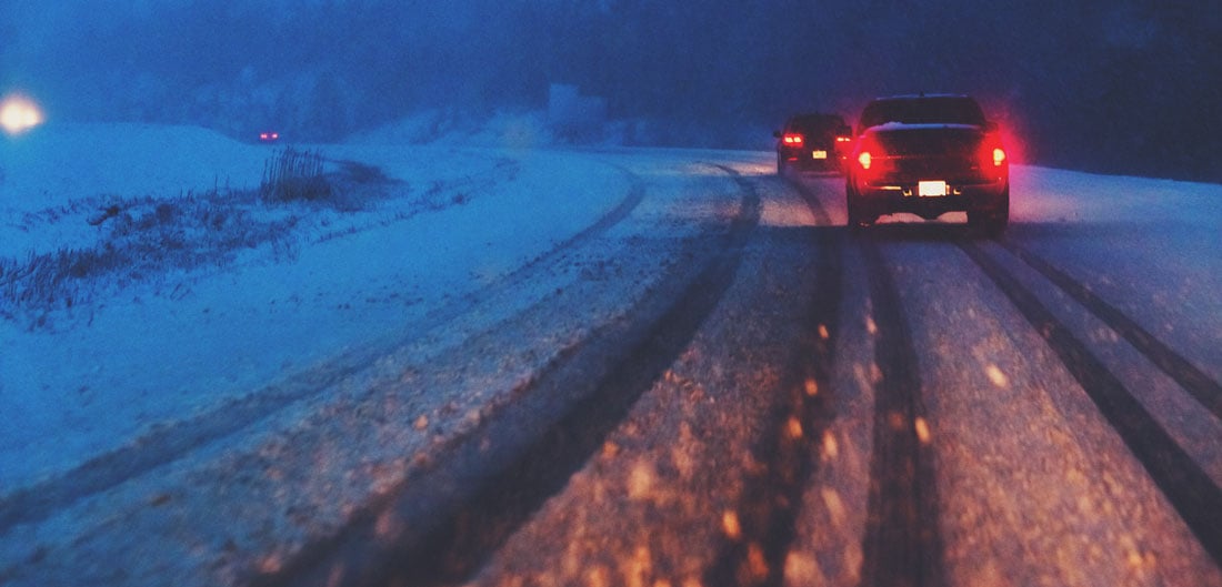 rear view of car with brake lights on slushy road