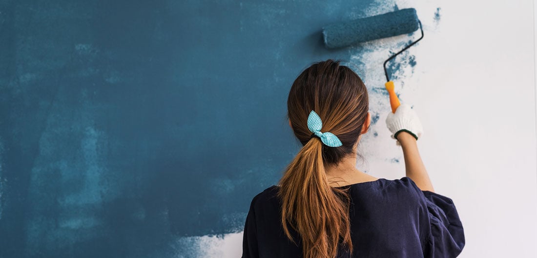 woman paints wall