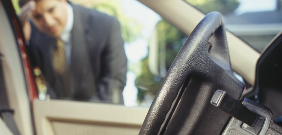 man looks in through driver's side car window