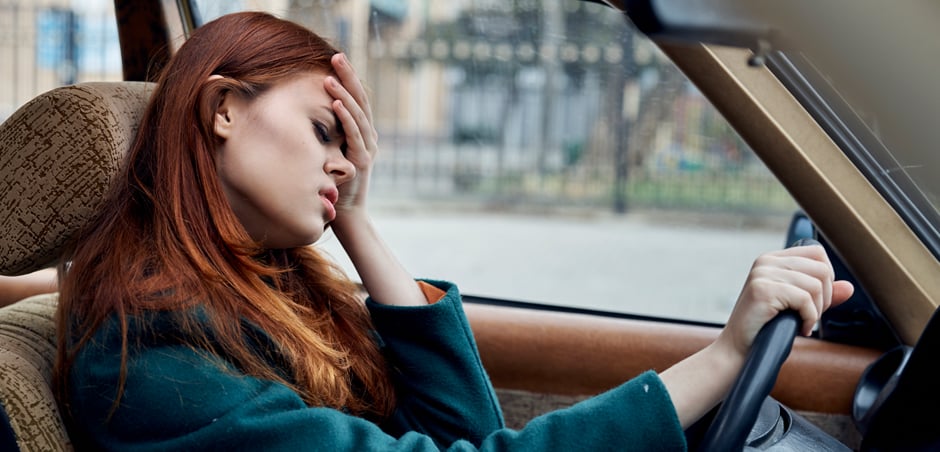 driver looks annoyed with hand on forehead