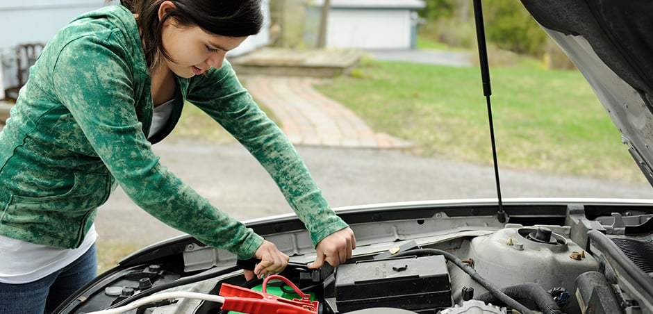 woman opens car hood to work on engine