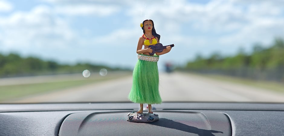 close up of hula dancer figurine on car dashboard