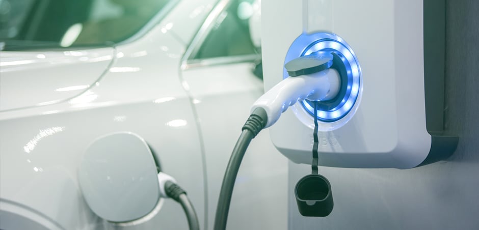 Close-up of car plugged into charging port.
