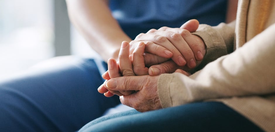 two people sitting holding hands
