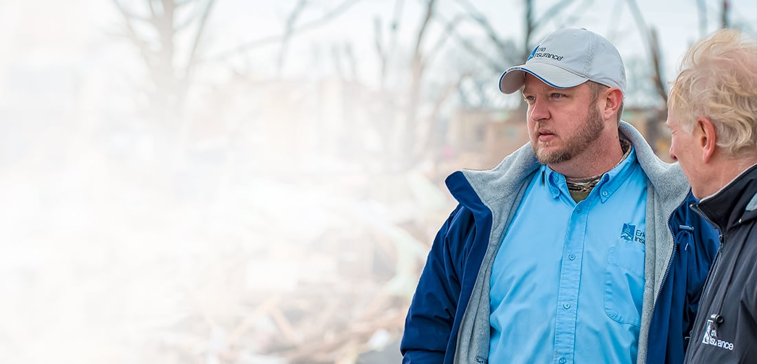 two people looking at the aftermath of a tornado 