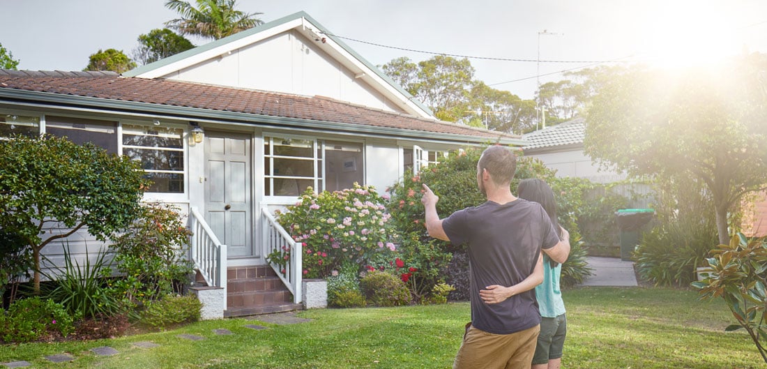 Couple pointing at house