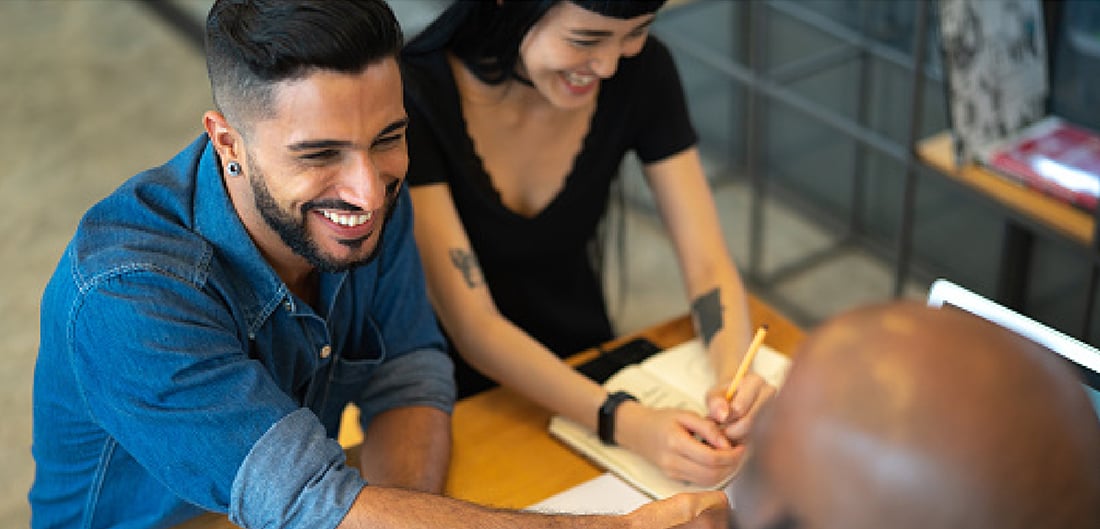 Two people smiling at a desk