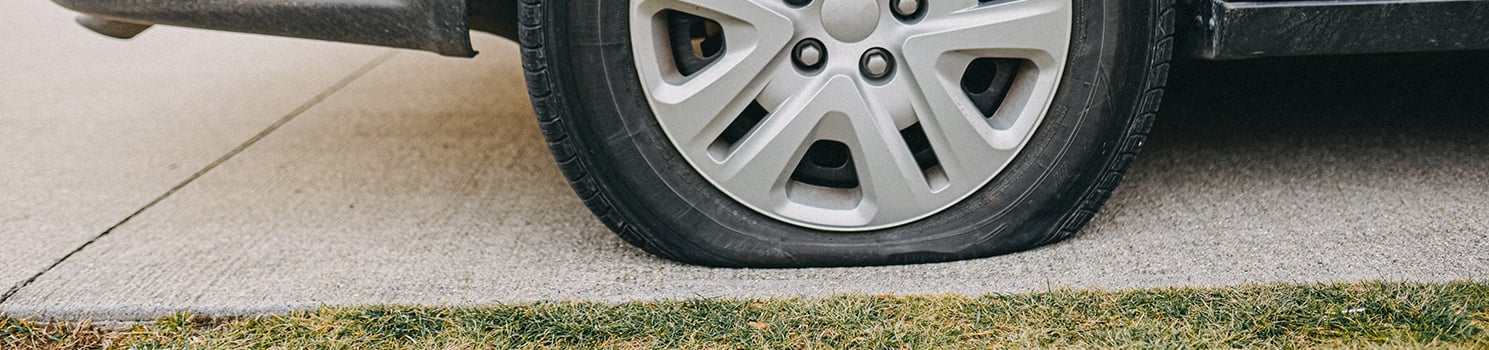 flat tire on car sitting in driveway