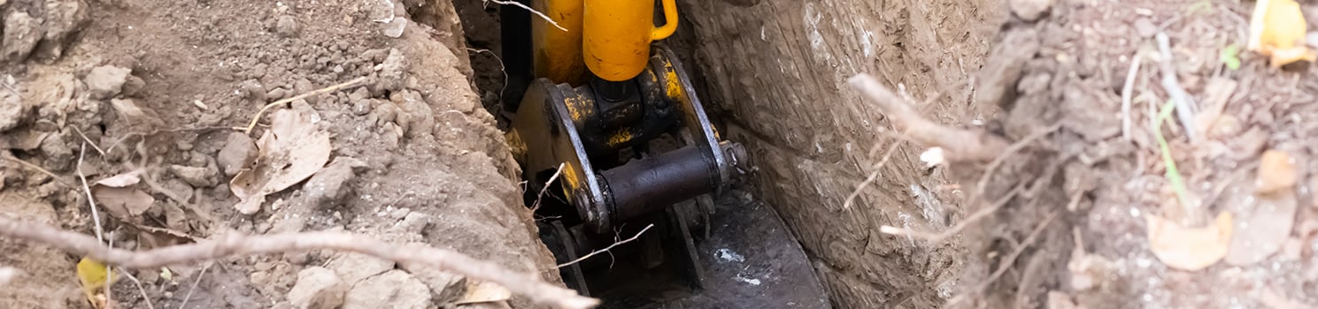 Excavator digging hole in the ground