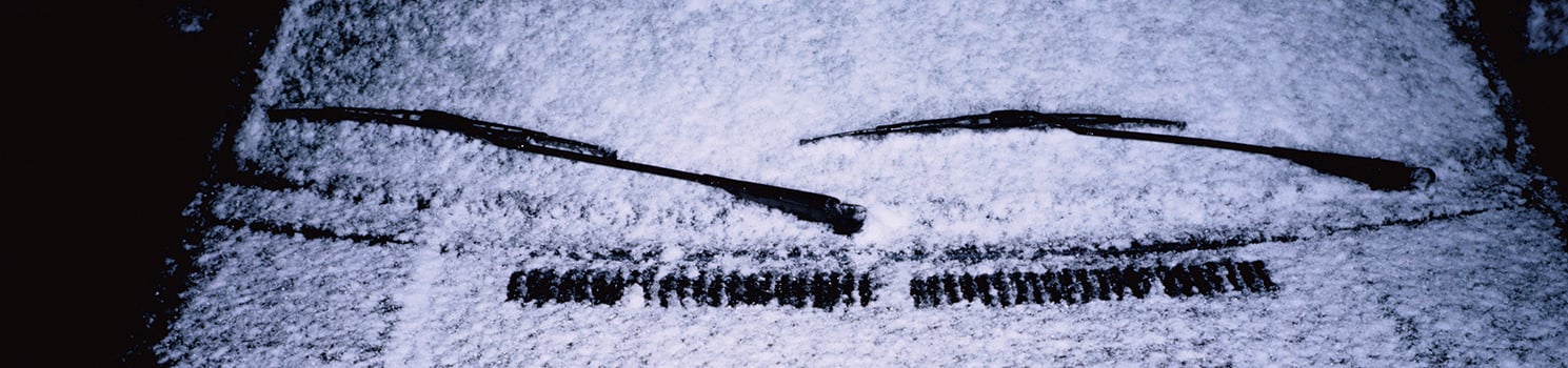 car with a snowy windshield and wipers on it