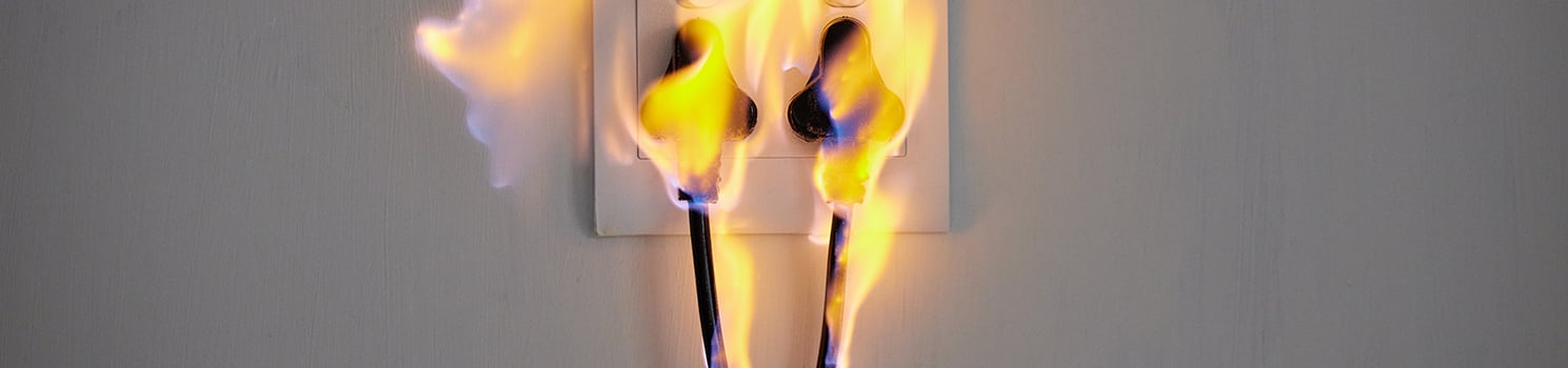 electrical cords on fire plugged into an outlet