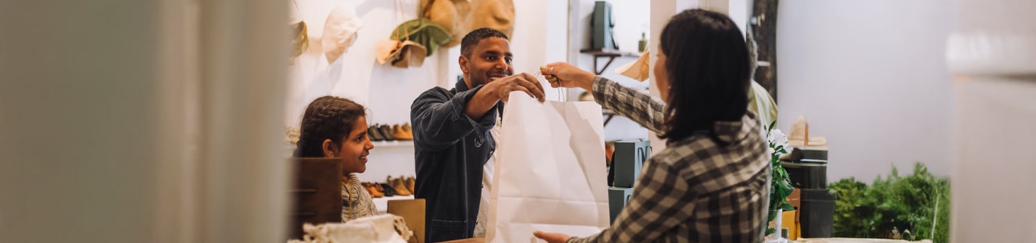 woman handing man a plastic bag