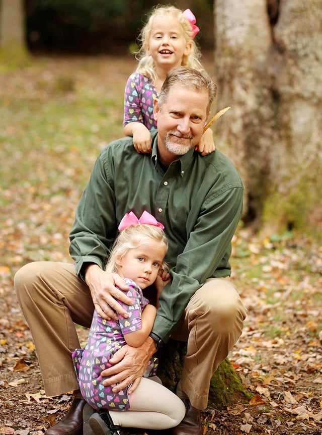 Richard Baker poses for a family photo with his two daughters.