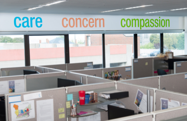 A sign on the wall of the Erie Insurance FNOL department says "Care, Concern, Compassion"