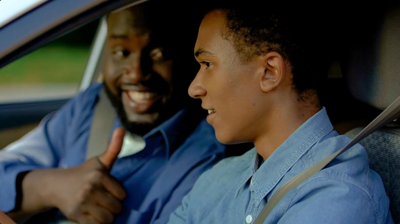 a father giving his son a thumbs up in the car