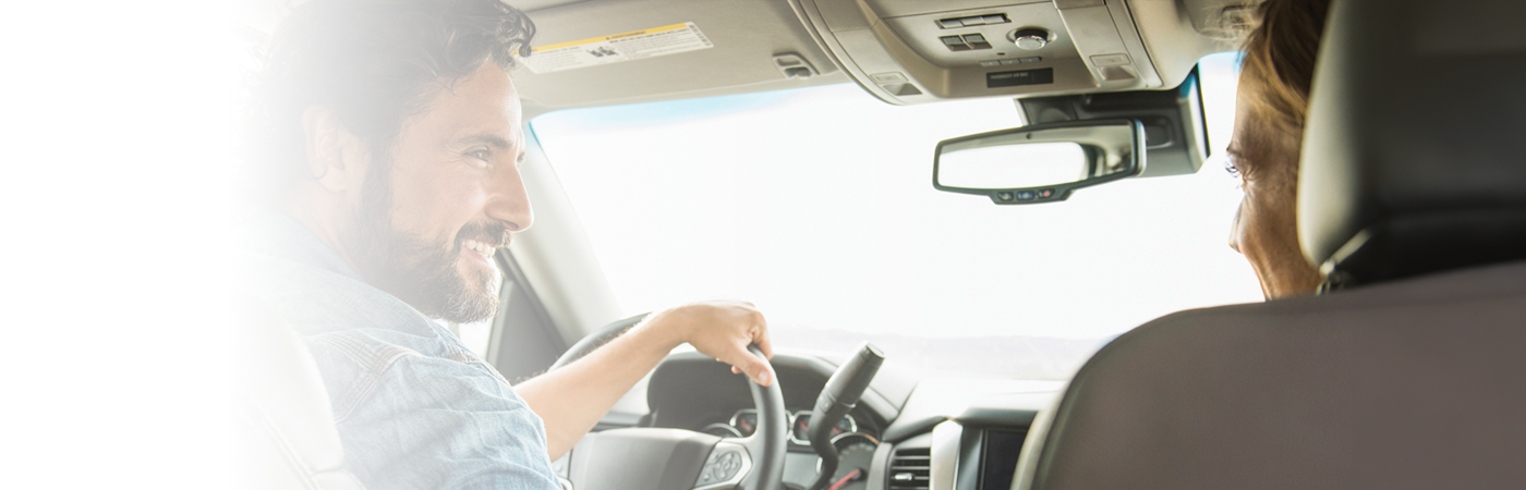 man and woman smiling at each other while driving