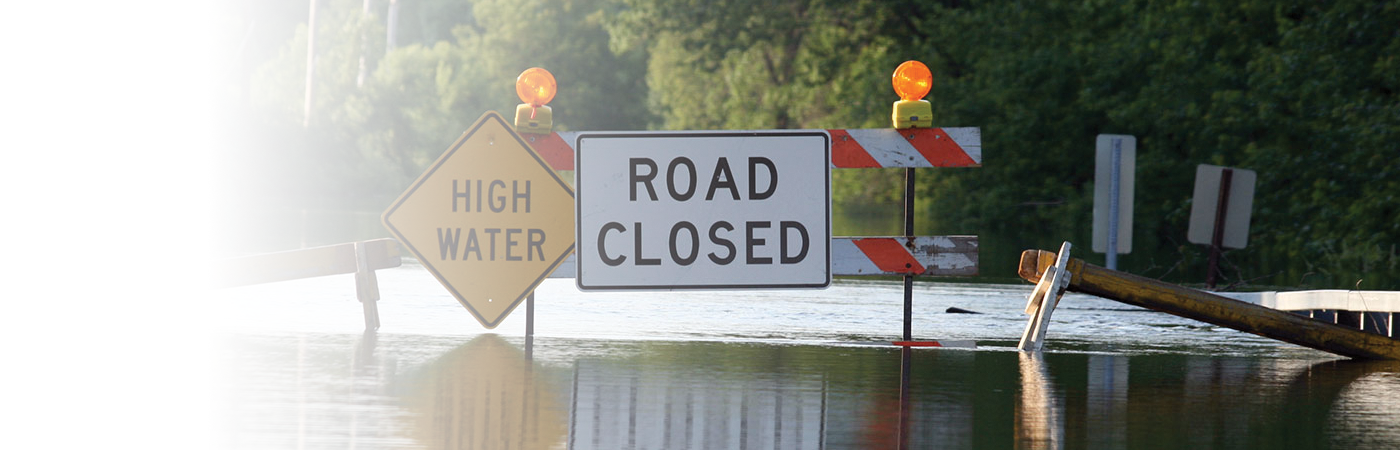 road closed sign on flooded road