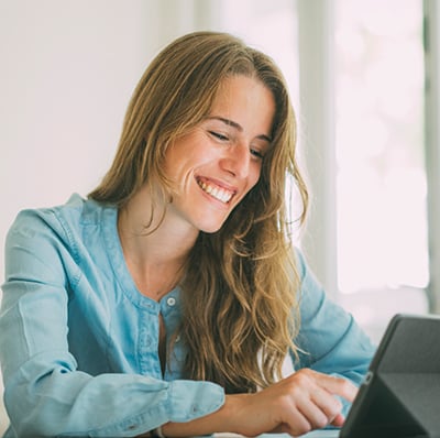 woman smiling at tablet