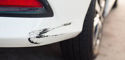 White car with scratch on bumper