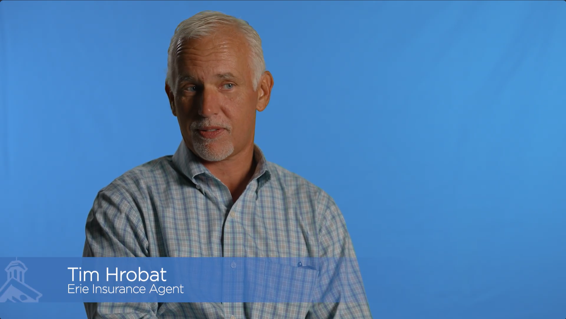 white haired man in front of blue background