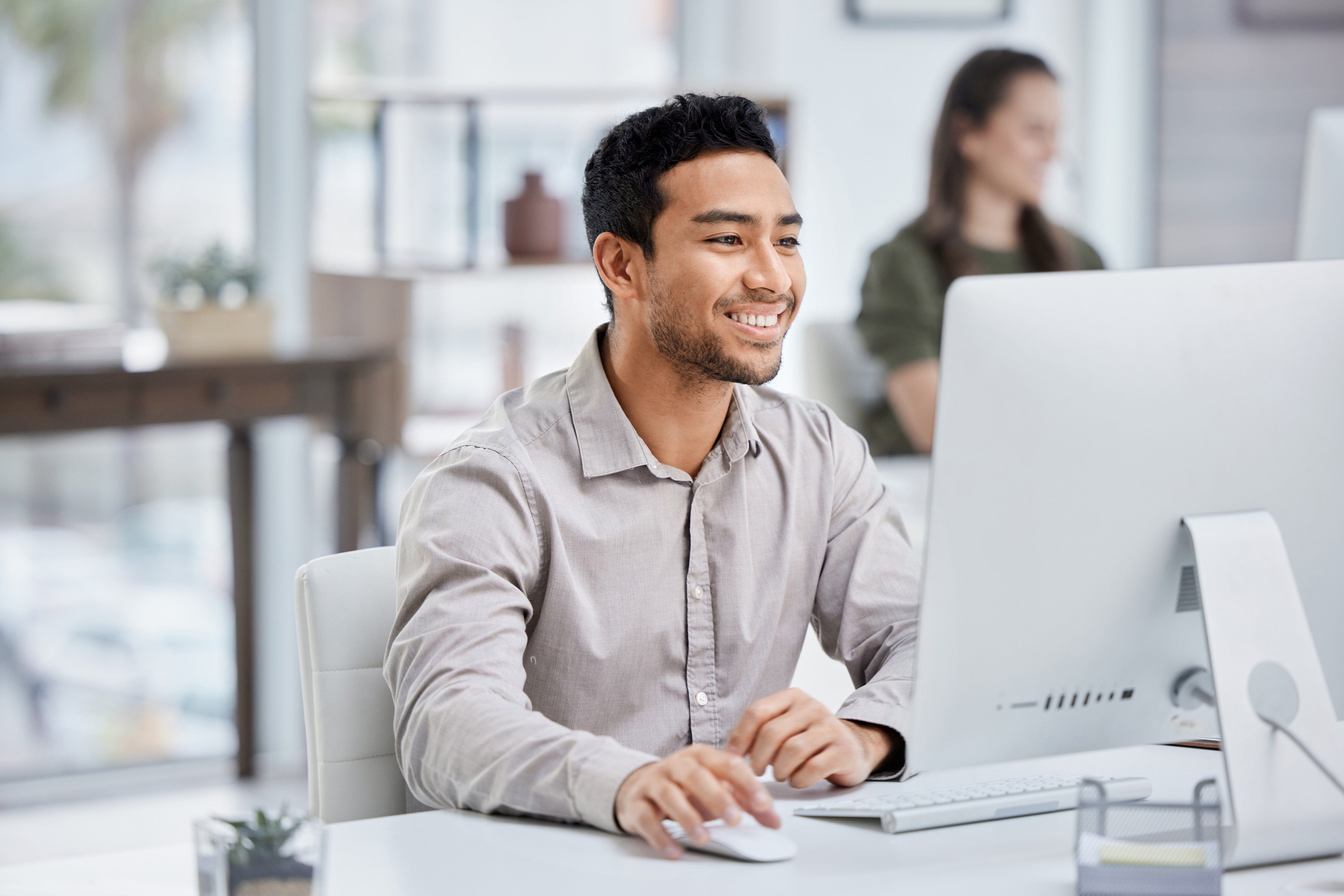 IT employee looks optimistically at his computer screen