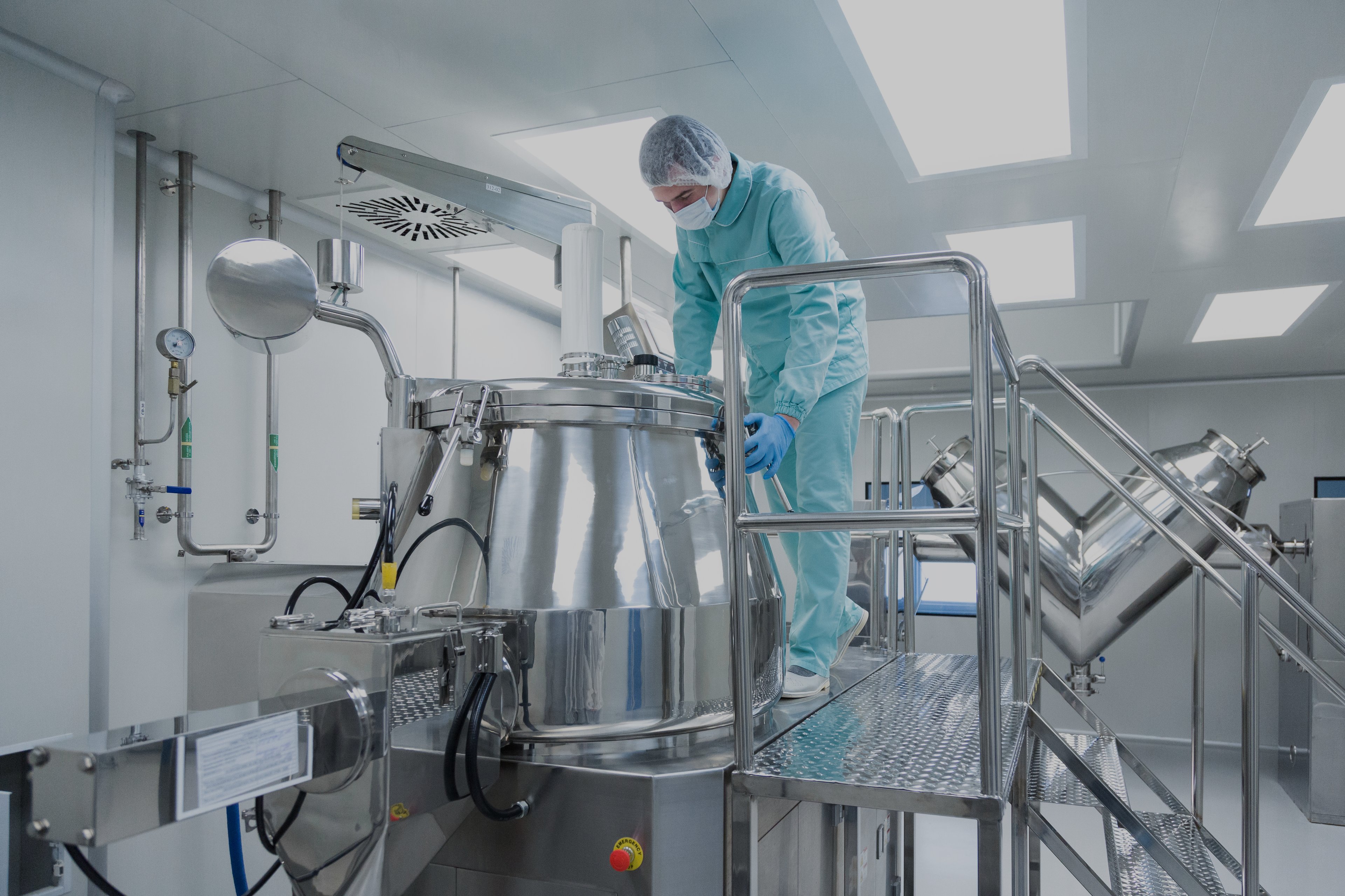 Lab technician working on a large stainless steel tank