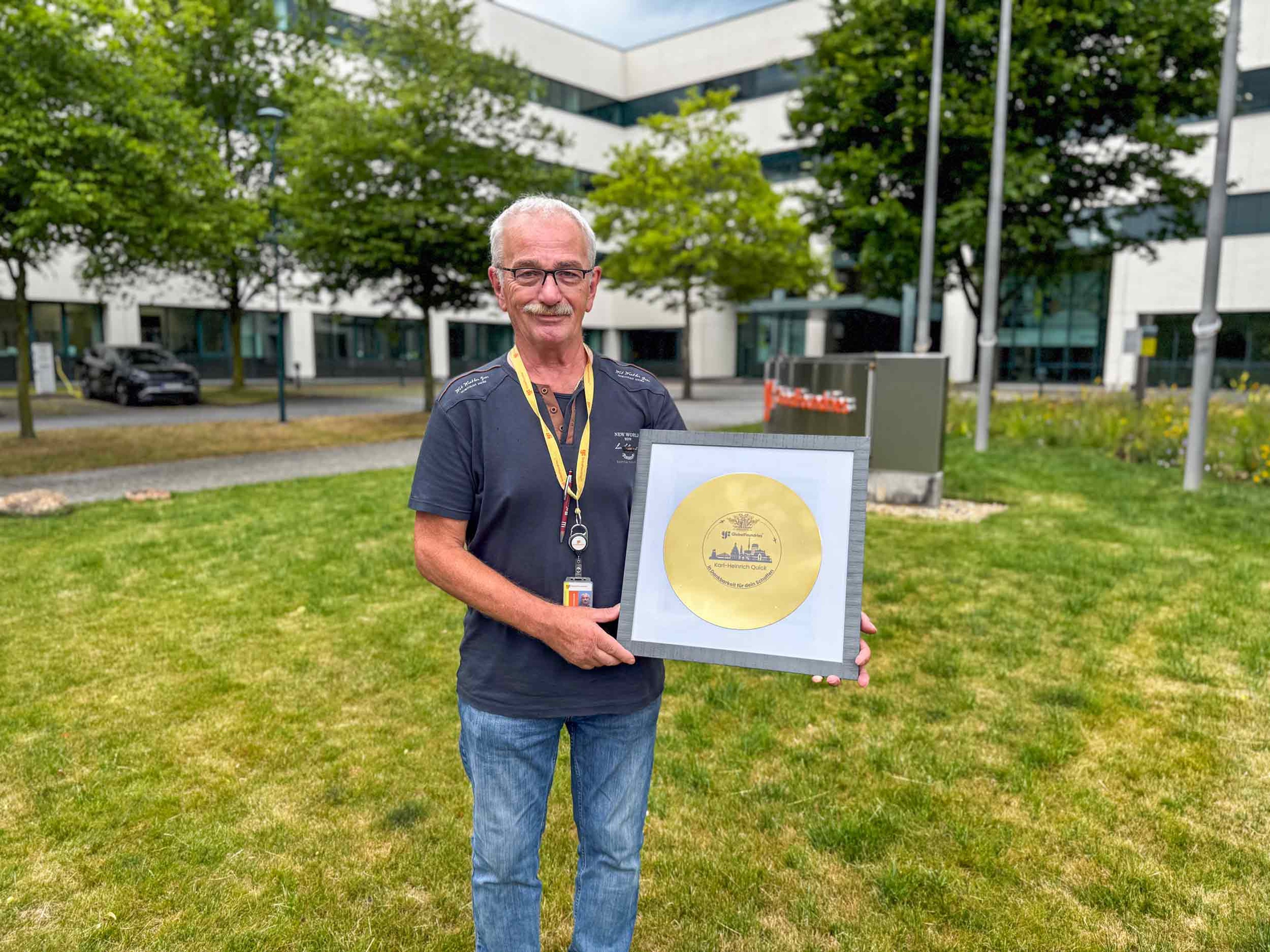 Retired Exyte employee Karlheinz Quick presents his farewell gift, a gold-plated 300 mm wafer with a personal dedication.