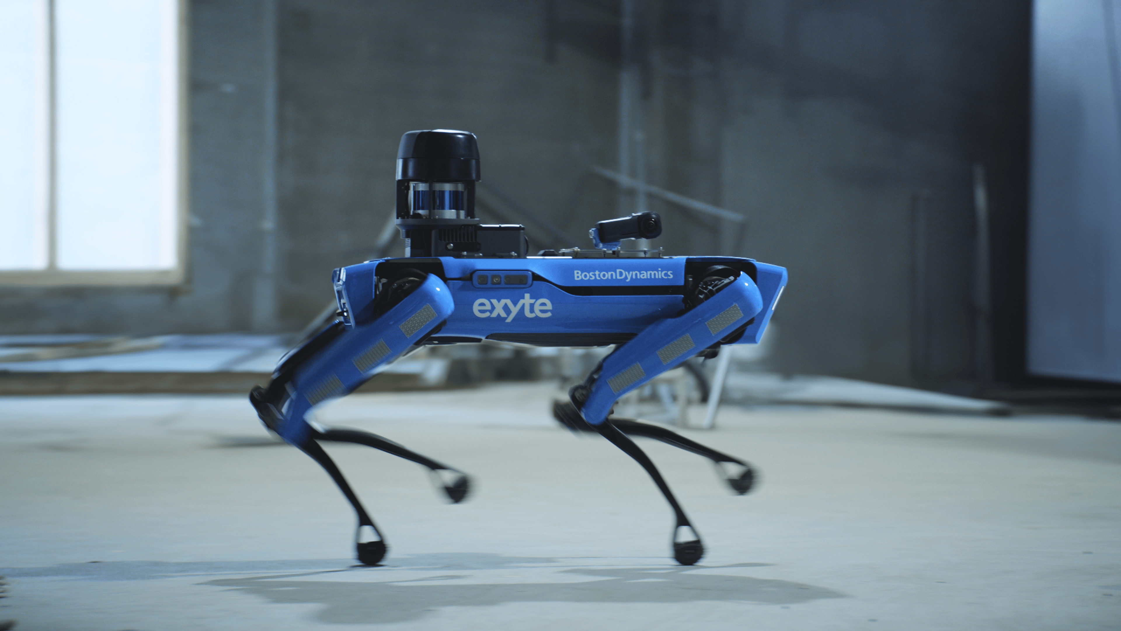 The robot dog, named "Rexyte," is seen in a construction environment. Branded with "Exyte" and developed by Boston Dynamics, Rexyte's agile frame highlights its advanced capabilities for navigating complex worksites.