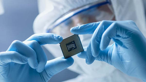 Two hands holding a computer chip