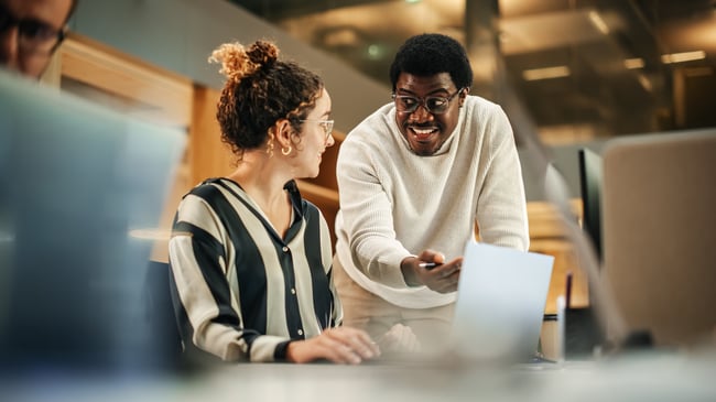 Photo of two people talking in an office environment