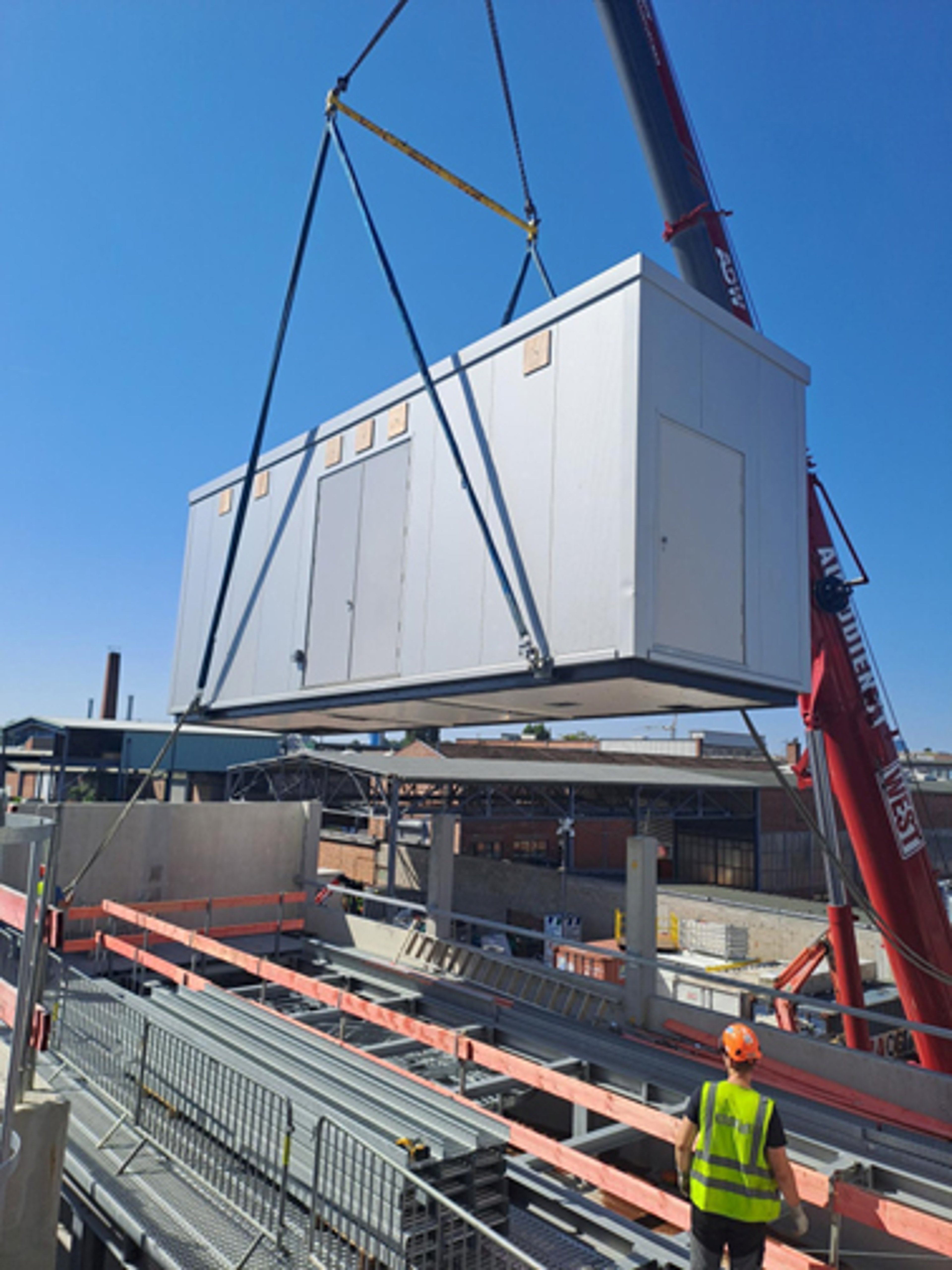 A modular data center unit is installed on site with the help of a crane, on an Exyte data center project site in Germany.