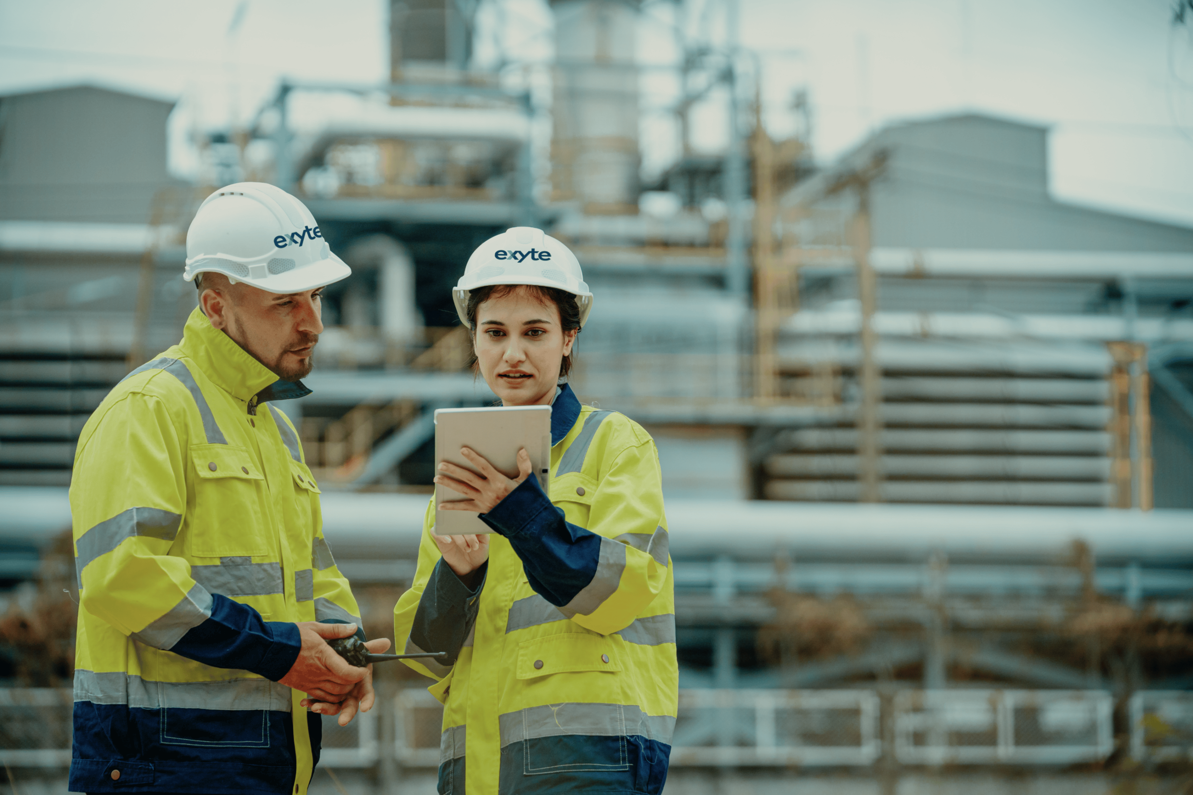 Ingenieursdienstleistungen sind ein Kernbestandteil von Exyte. Im Bild ein Ingenieur und eine Ingenieurin, die sich einen Plan anschauen