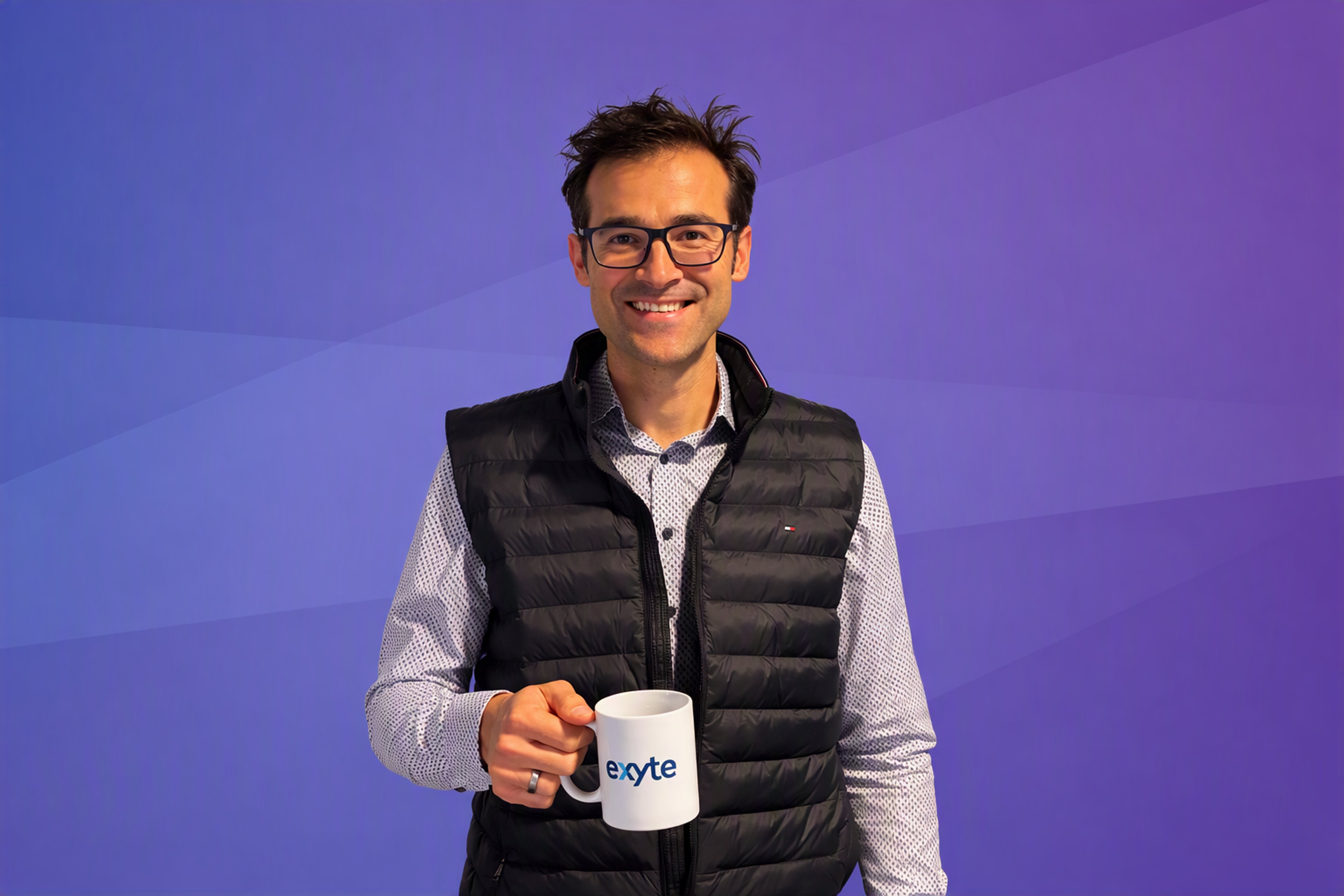 Portrait of Exyte engineer Samuel Keller, holding an Exyte mug in his right hand