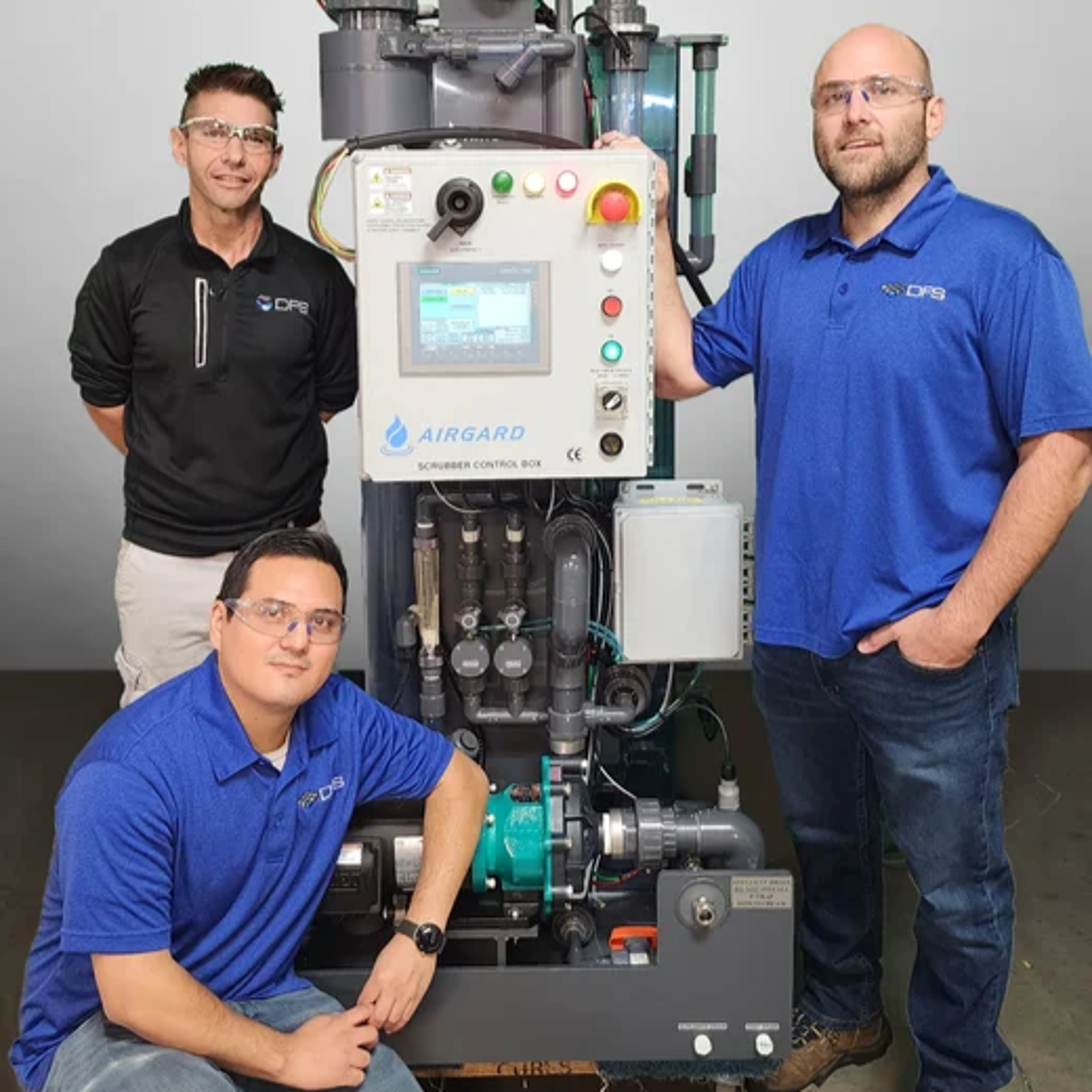 Three employees of Exyte subsidiary Airgard with an air scrubber system