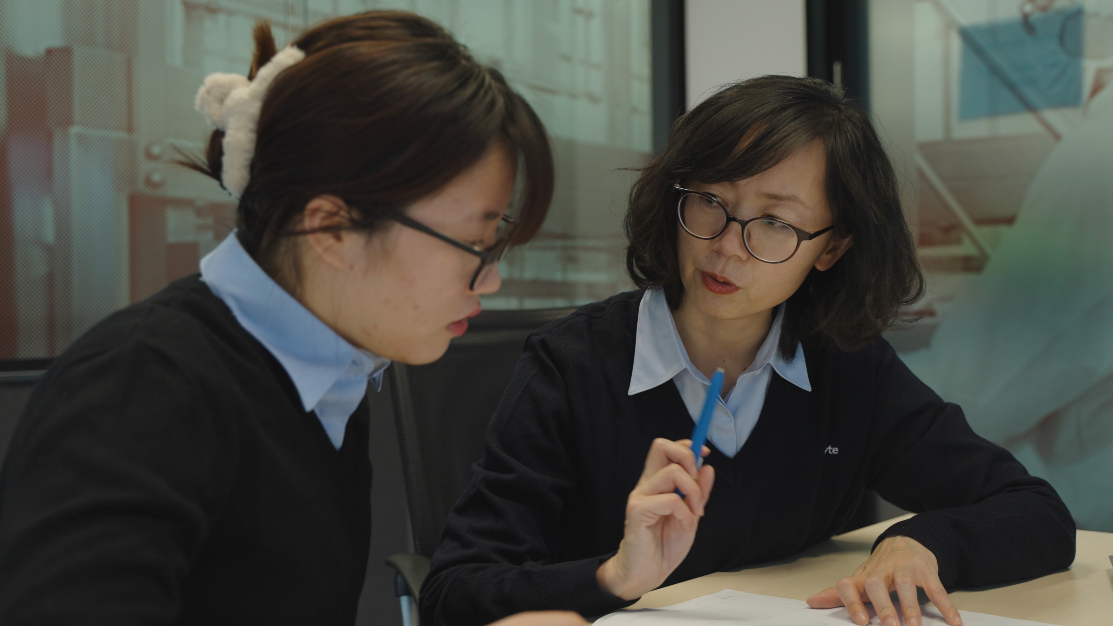 Two female Exyte engineers communicate over a document