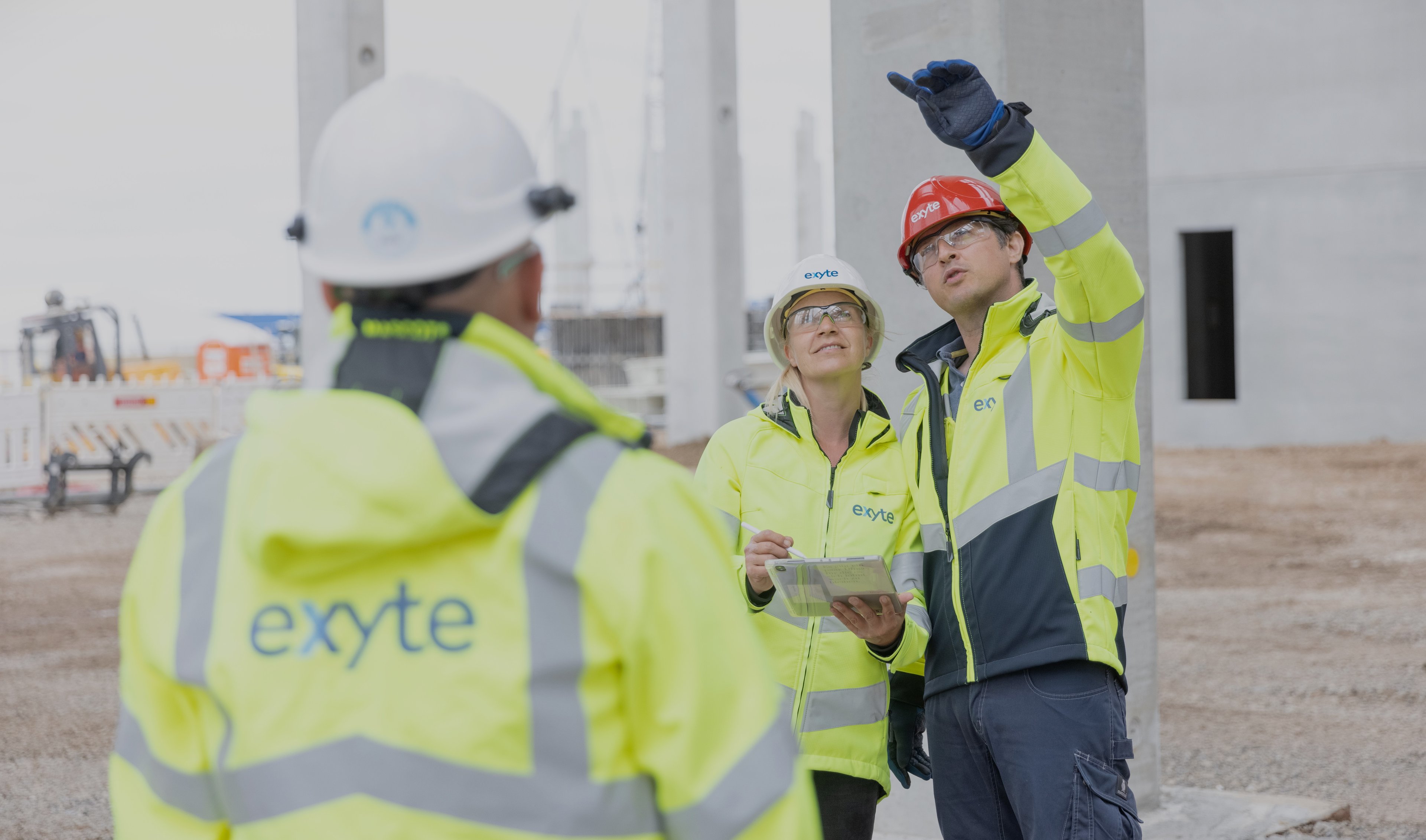 Group of Exyte employees on a project site wearing Personal protective equipment