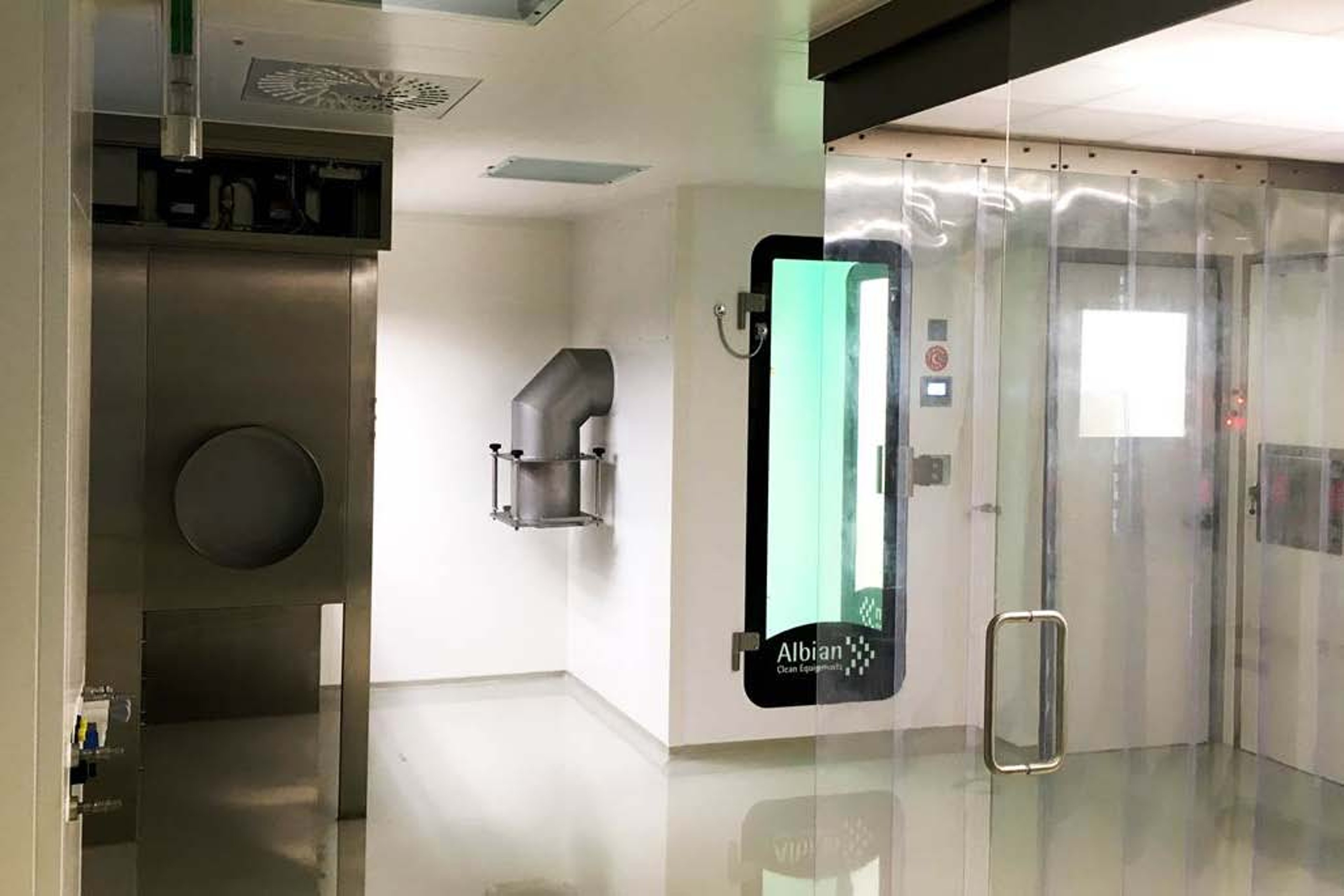 An interior view of cleanrooms for a lyophilizer in Bubendorf, featuring stainless steel equipment, cleanroom doors, and transparent plastic partitions.