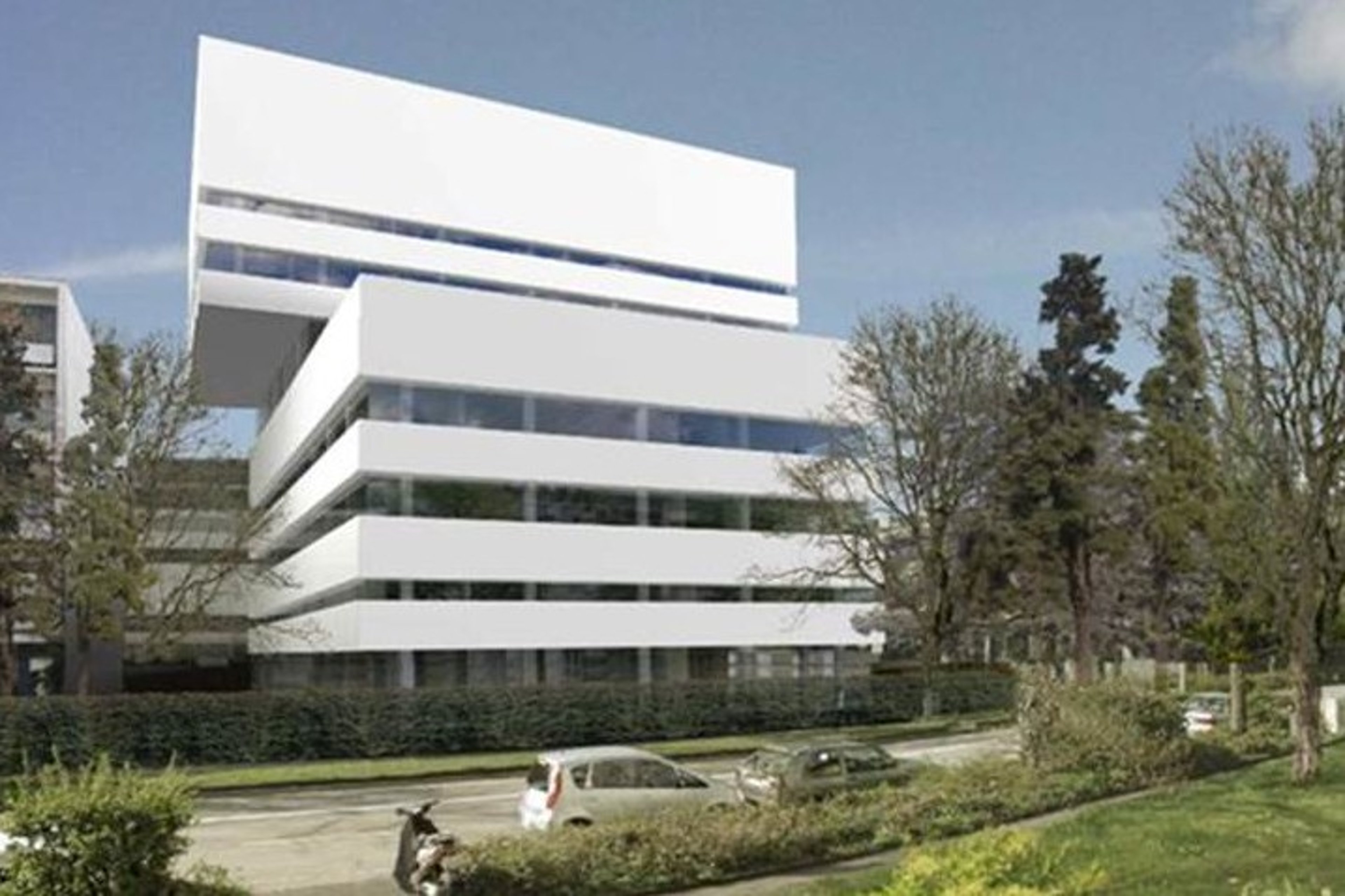 A modern R&D building in Basel, featuring a sleek white exterior with large windows and surrounded by trees and parked vehicles.