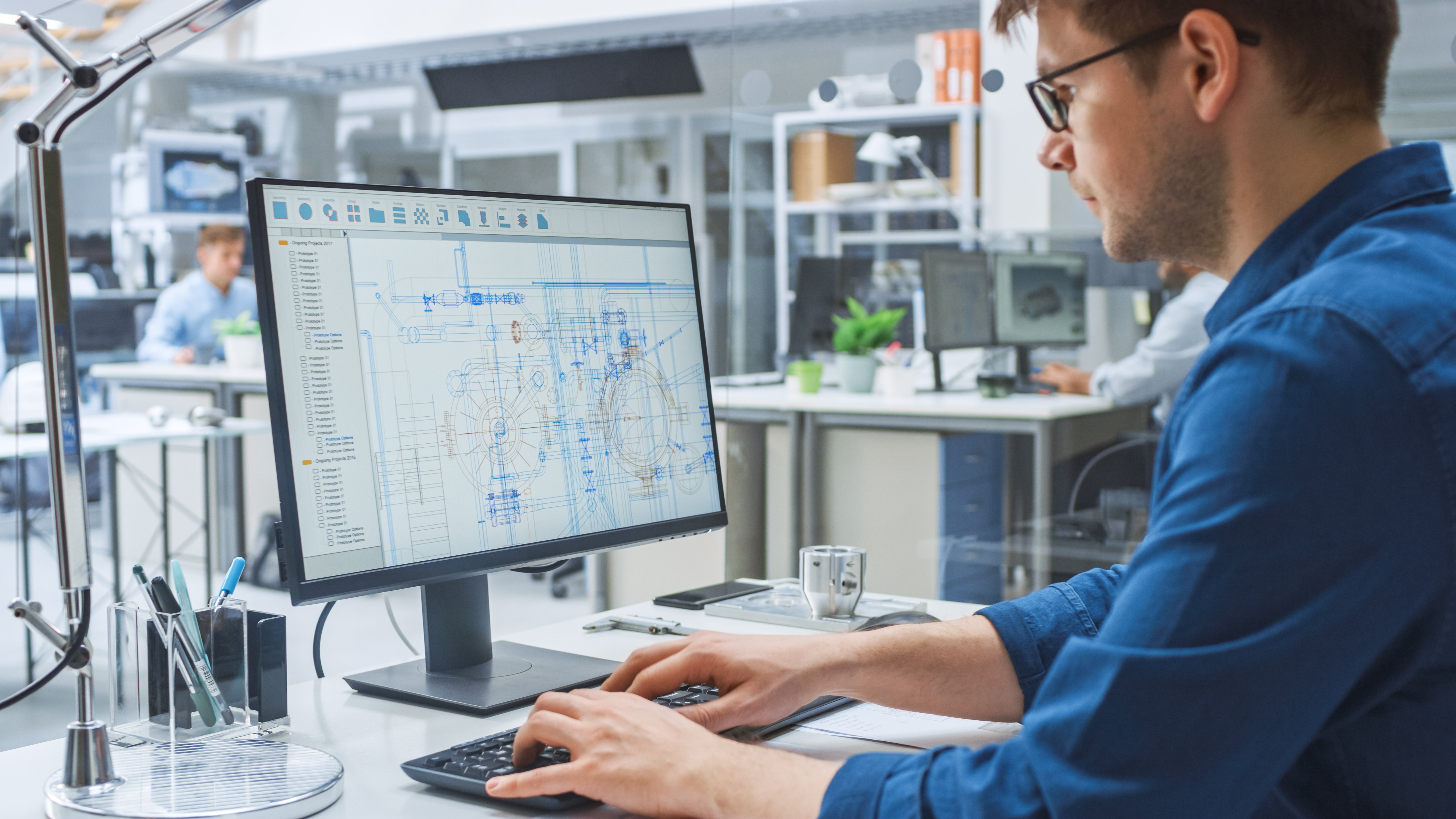 A man works in a computer program on the design of a facility