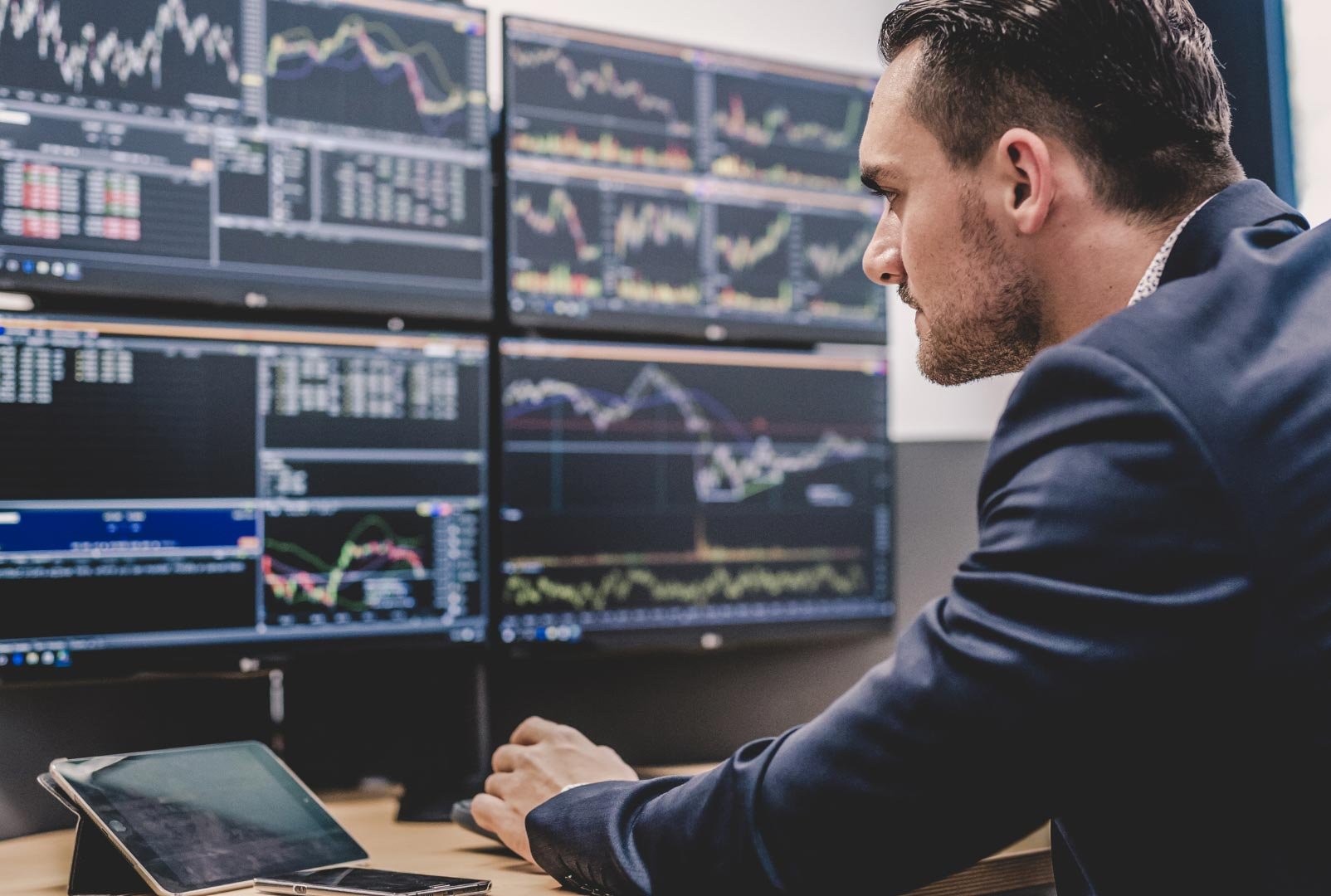 A man analyzing multiple stock market screens.