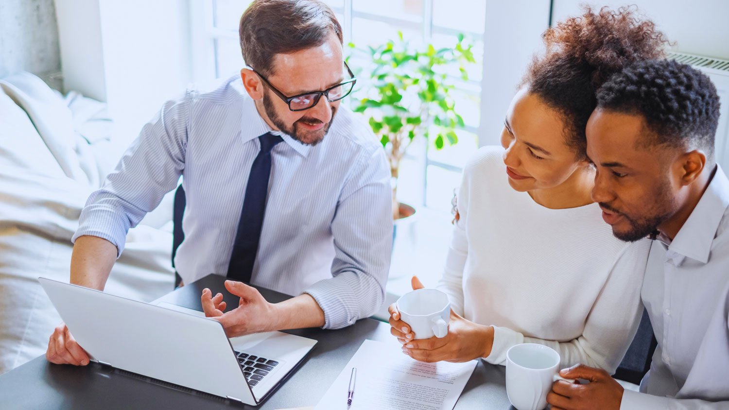 A couple engaged in a legal discussion with a lawyer in a bright office
